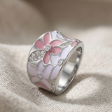 "Anello in Oro Bianco con Fiori Rosa" can be rewritten as "Anello in Oro Bianco Decorato con Fiori Rosa".